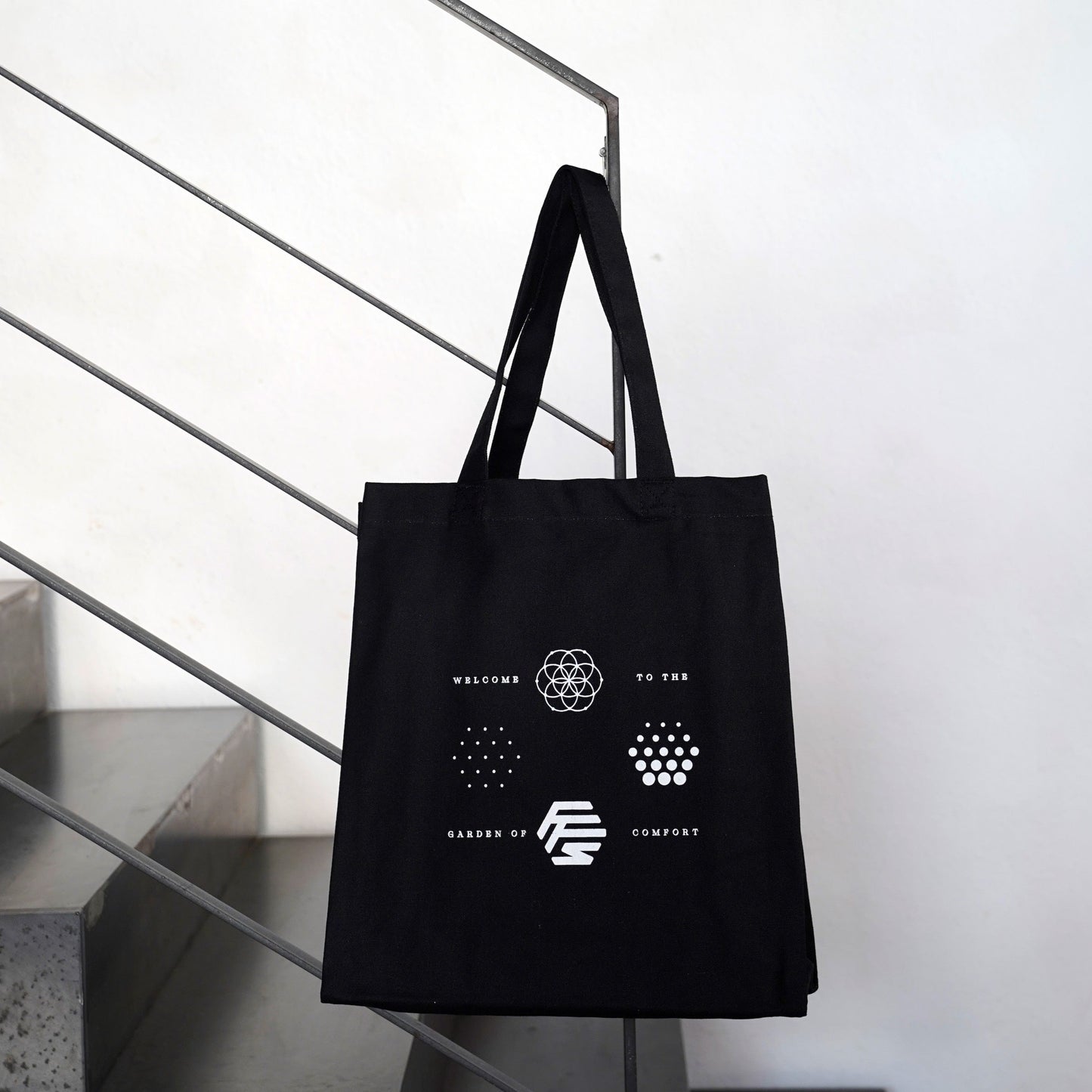 Flowers for Society OG logos jute bag black front view hanging on stair railing