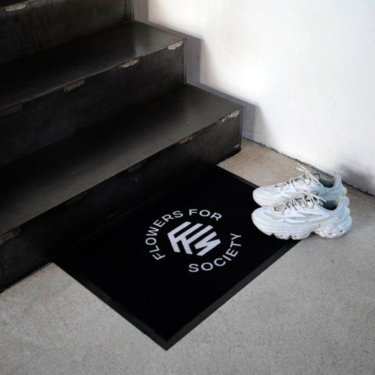 Flowers For Society door mat white logo on black ground in front of stairs
