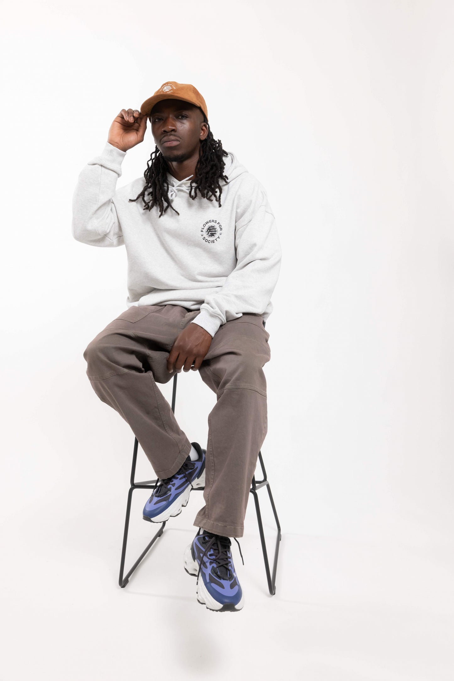 Flowers for Society Cord Cap brown frontview worn by model sitting on stool