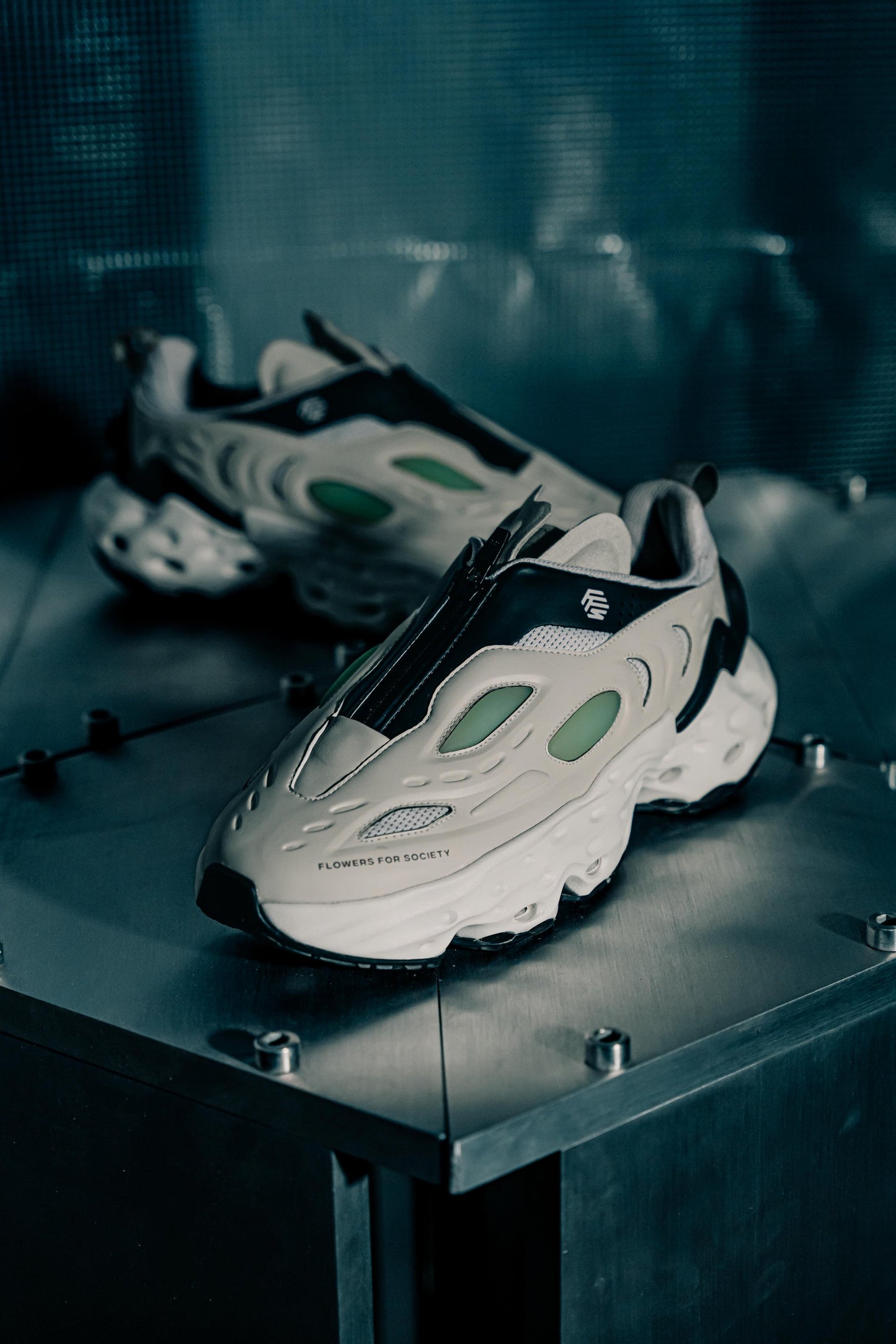Flowers for Society Sneaker Seed.One Memo-Z Kah Bane collaboration sideview standing on a metallic base