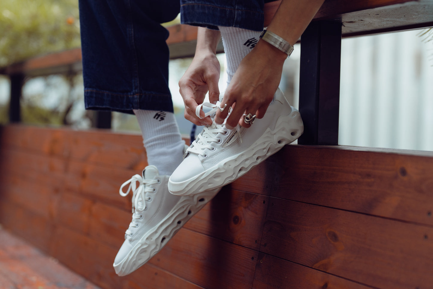 Flowers For Society Sneaker Radicle Topless white sideview worn by model sitting on wooden bench