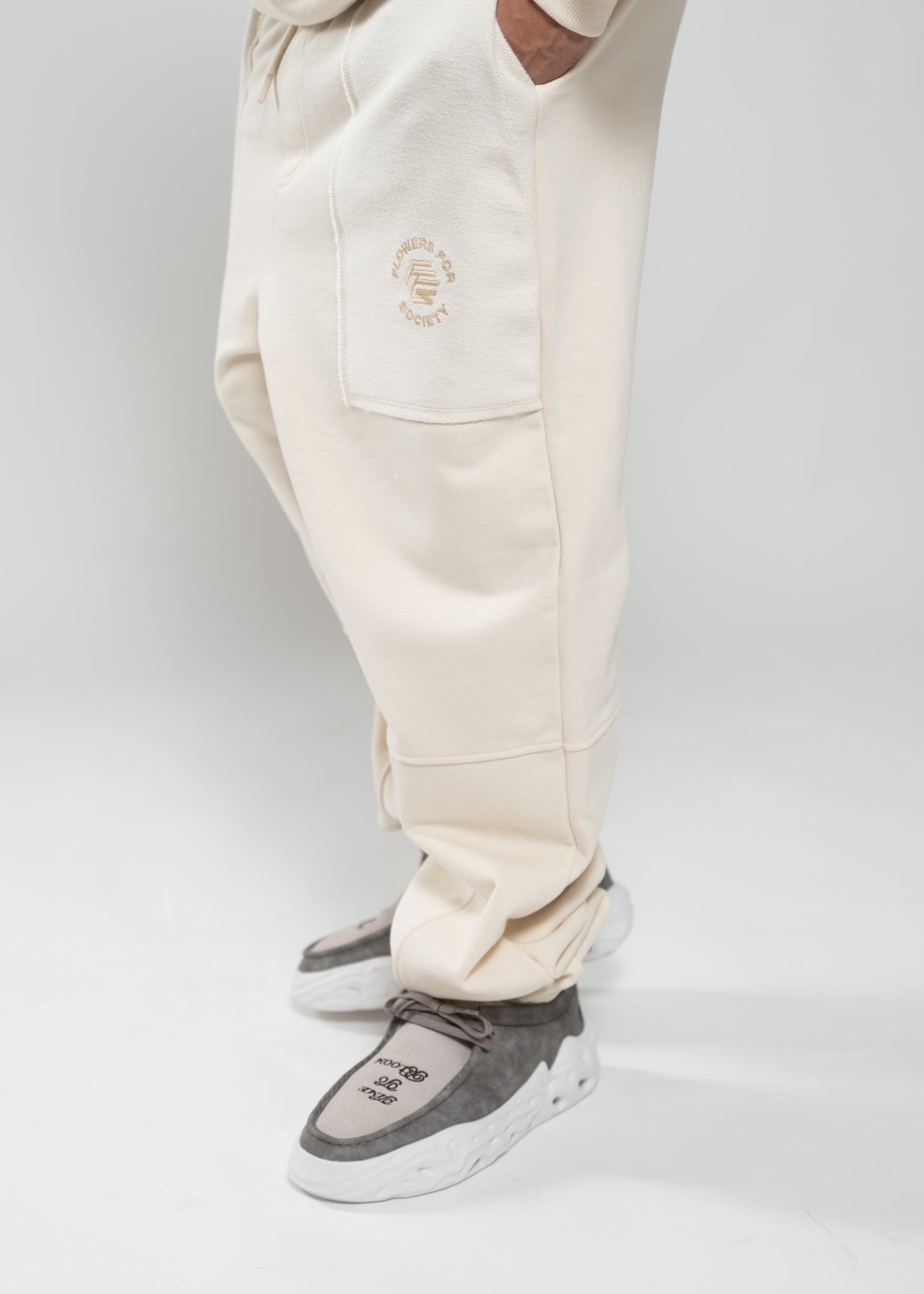 Flowers for Society Basic Jogger pant off white sideview worn by model Ben standing